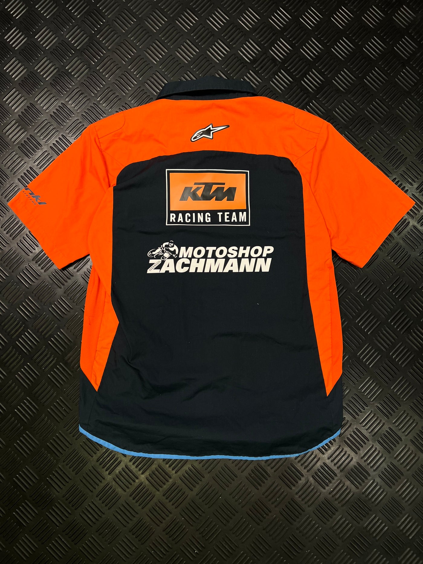 Vista trasera de camisa KTM Racing Team negra y naranja
