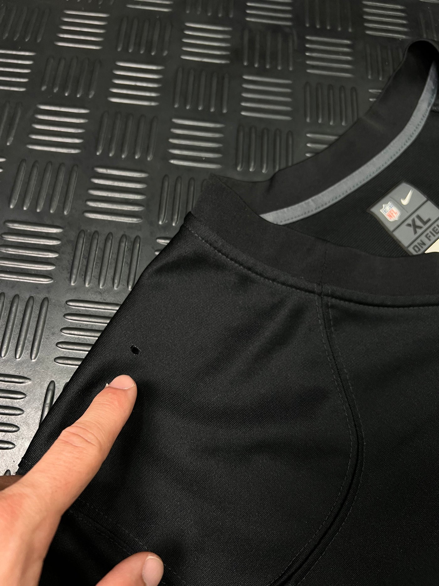 Detalle de pequeño agujero en manga de camiseta NFL Nike Raiders