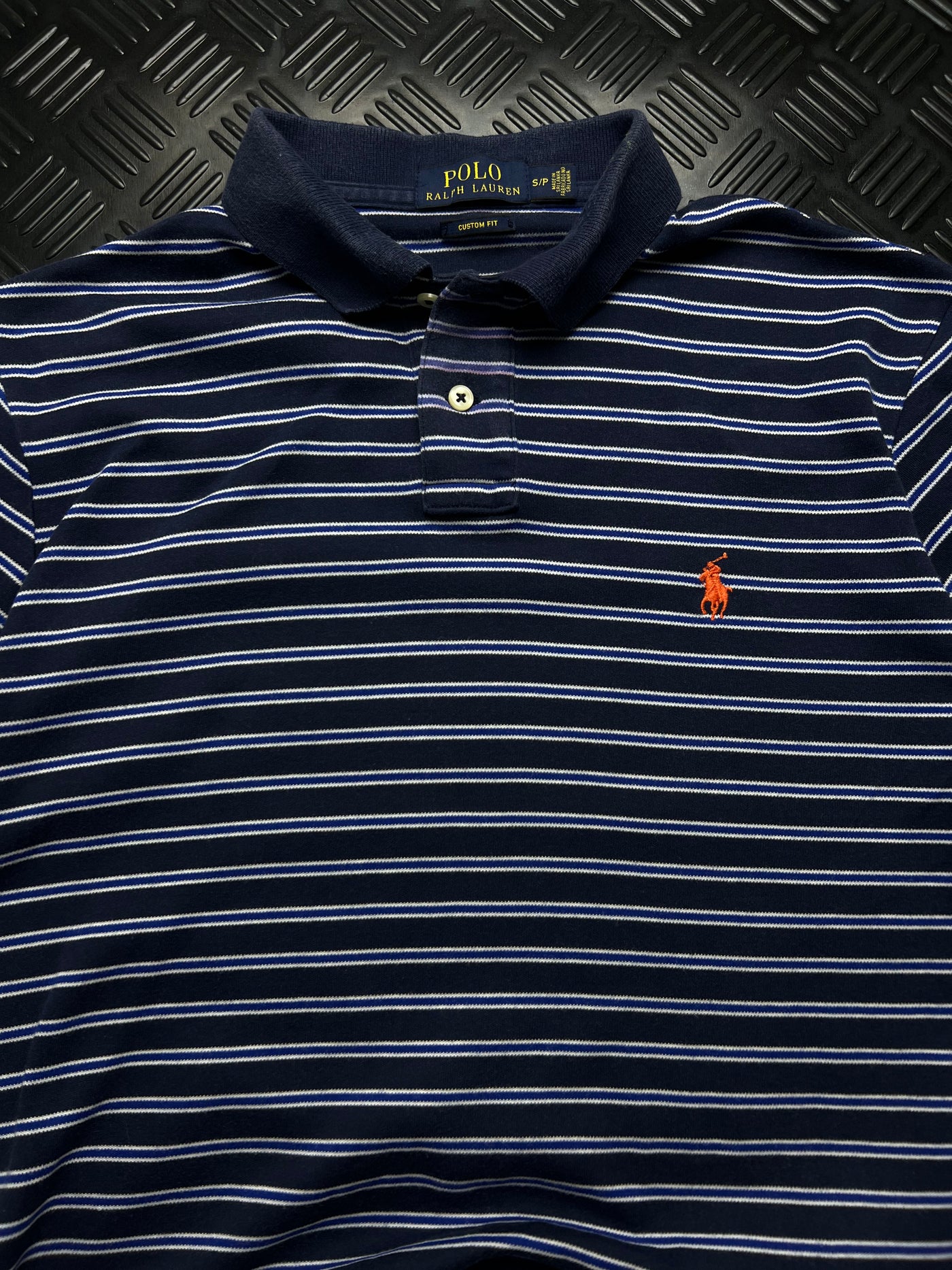 Detalle de rayas y Pony naranja de polo Ralph Lauren