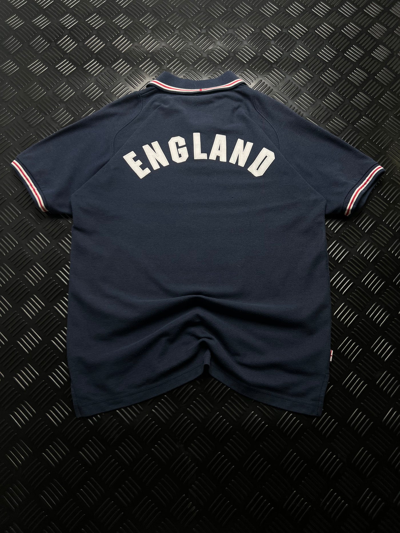 Vista trasera de polo Umbro Inglaterra con inscripción ENGLAND