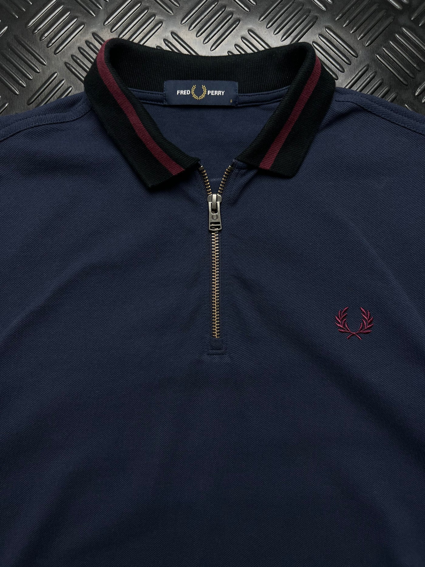 Detalle de etiqueta talla S, cremallera y Laurel Fred Perry