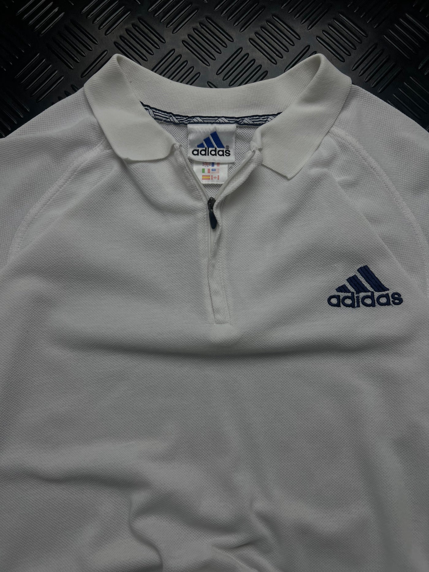Detalle de cremallera, etiqueta y logotipo Adidas