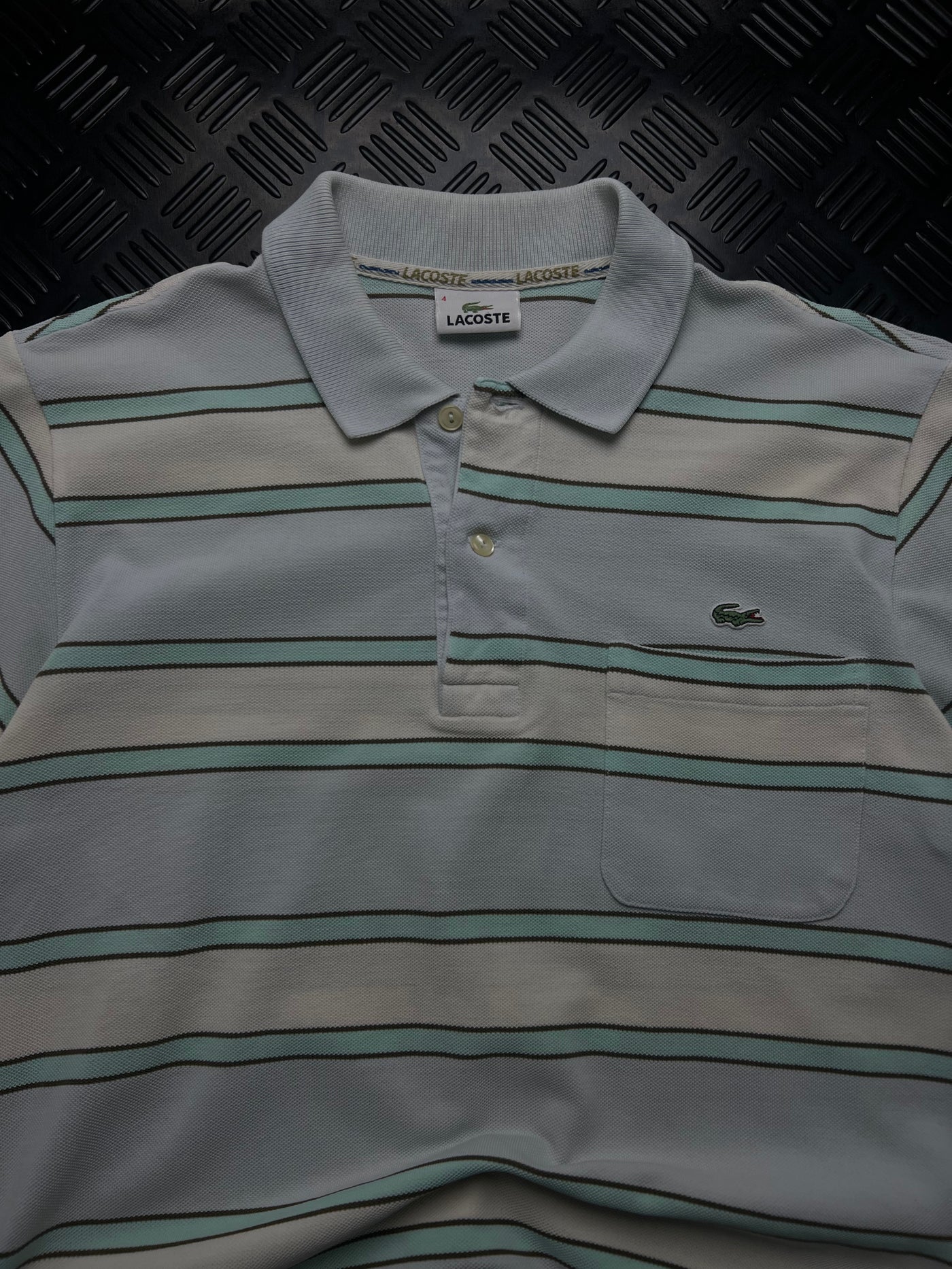 Detalle de polo lacoste rayas gris y verde