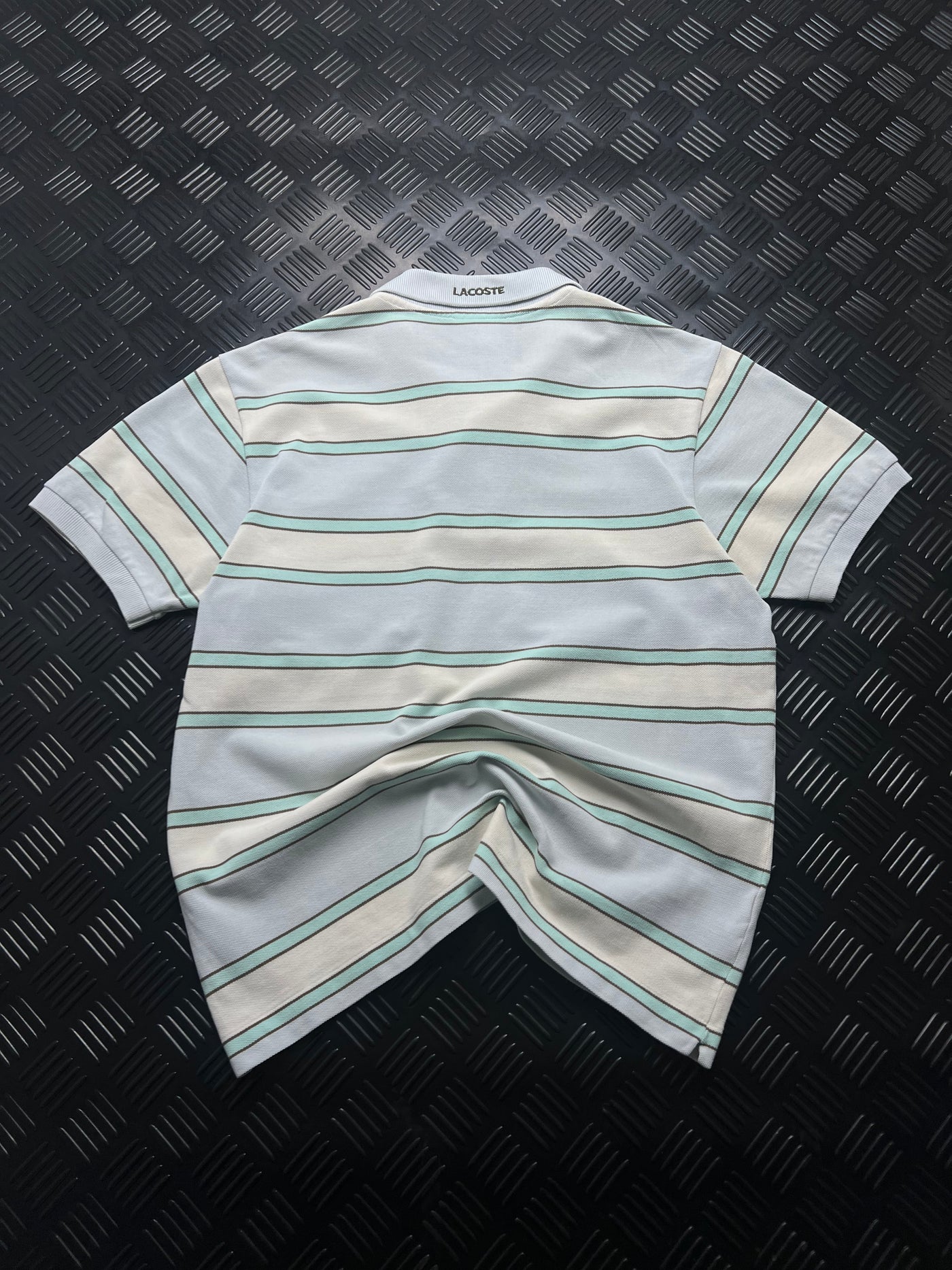 Detalle de polo lacoste rayas gris y verde