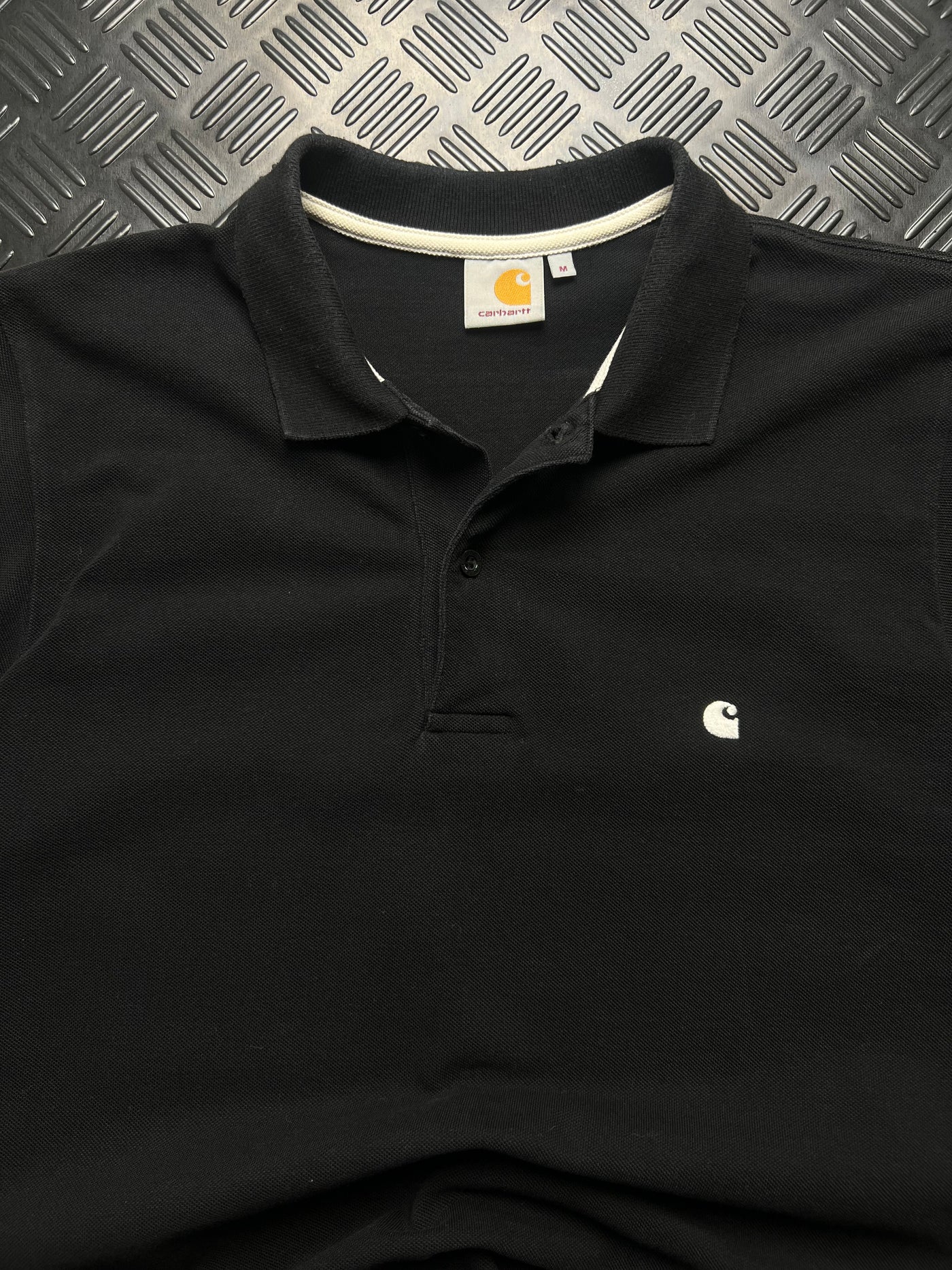Detalle de polo carhartt negro