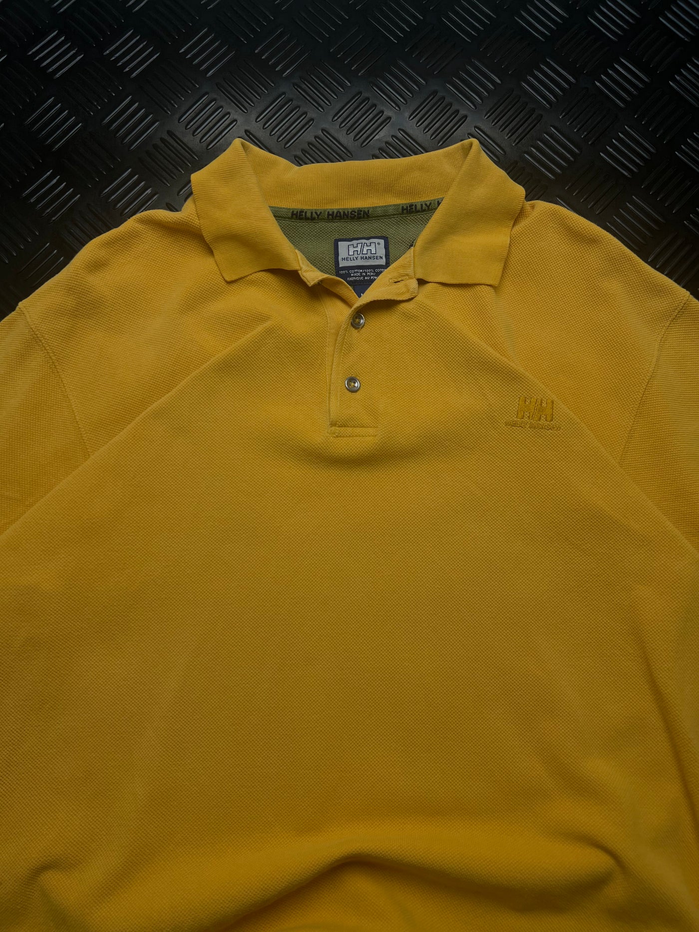 Detalle de polo helly hansen amarillo vintage