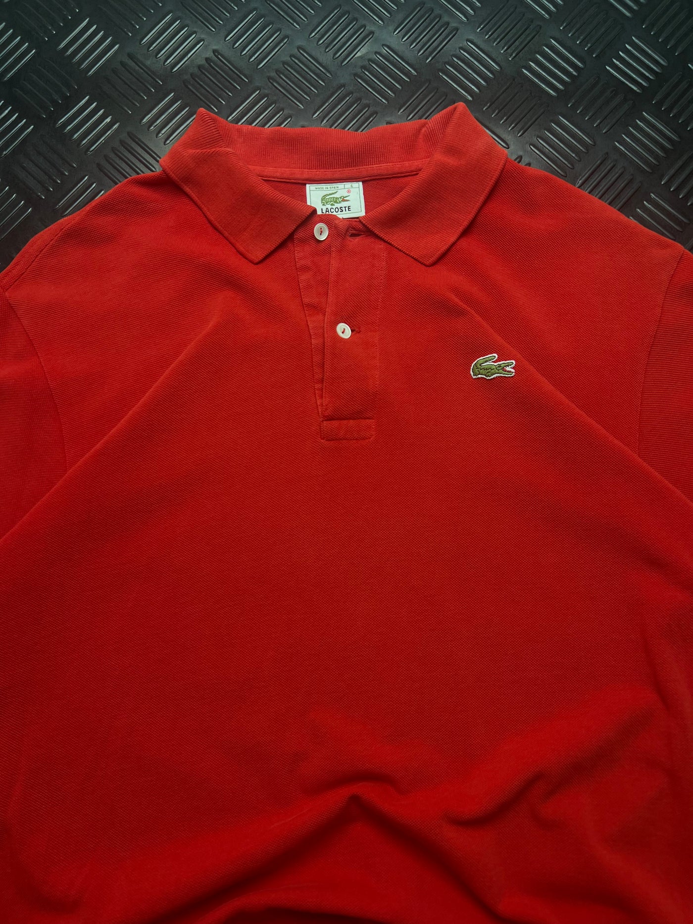Detalle de polo lacoste made in spain rojo