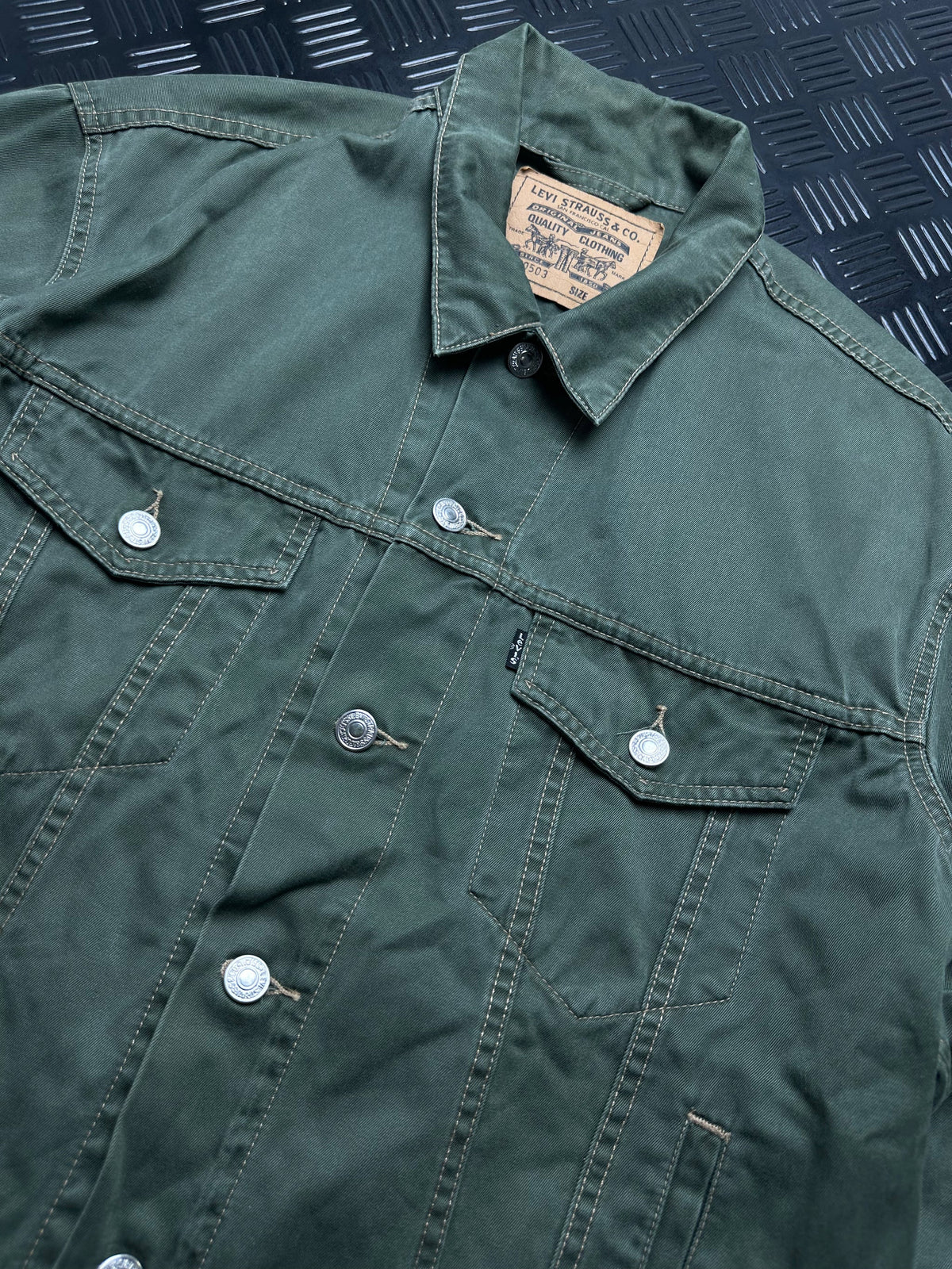 Detalle frontal de chaqueta Levi's Trucker verde oliva