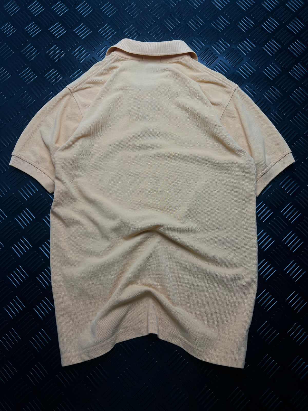Vista trasera de polo burberry con tapeta de cuadros, beige