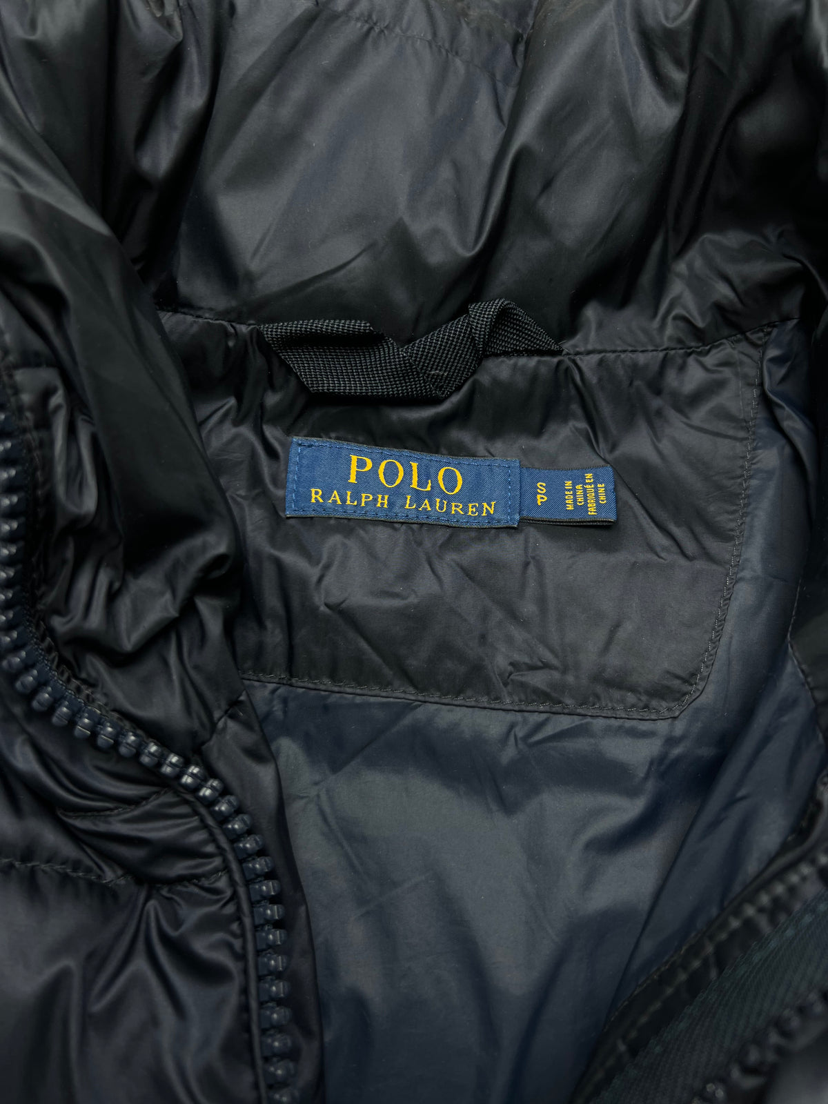 Detalle de chaqueta acolchada polo ralph lauren con bandera, azul marino