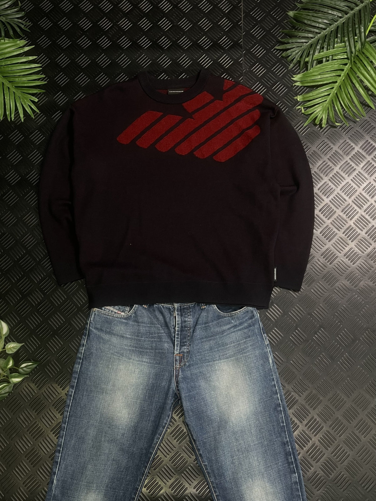 Jersey negro con detalle rojo combinado con vaqueros