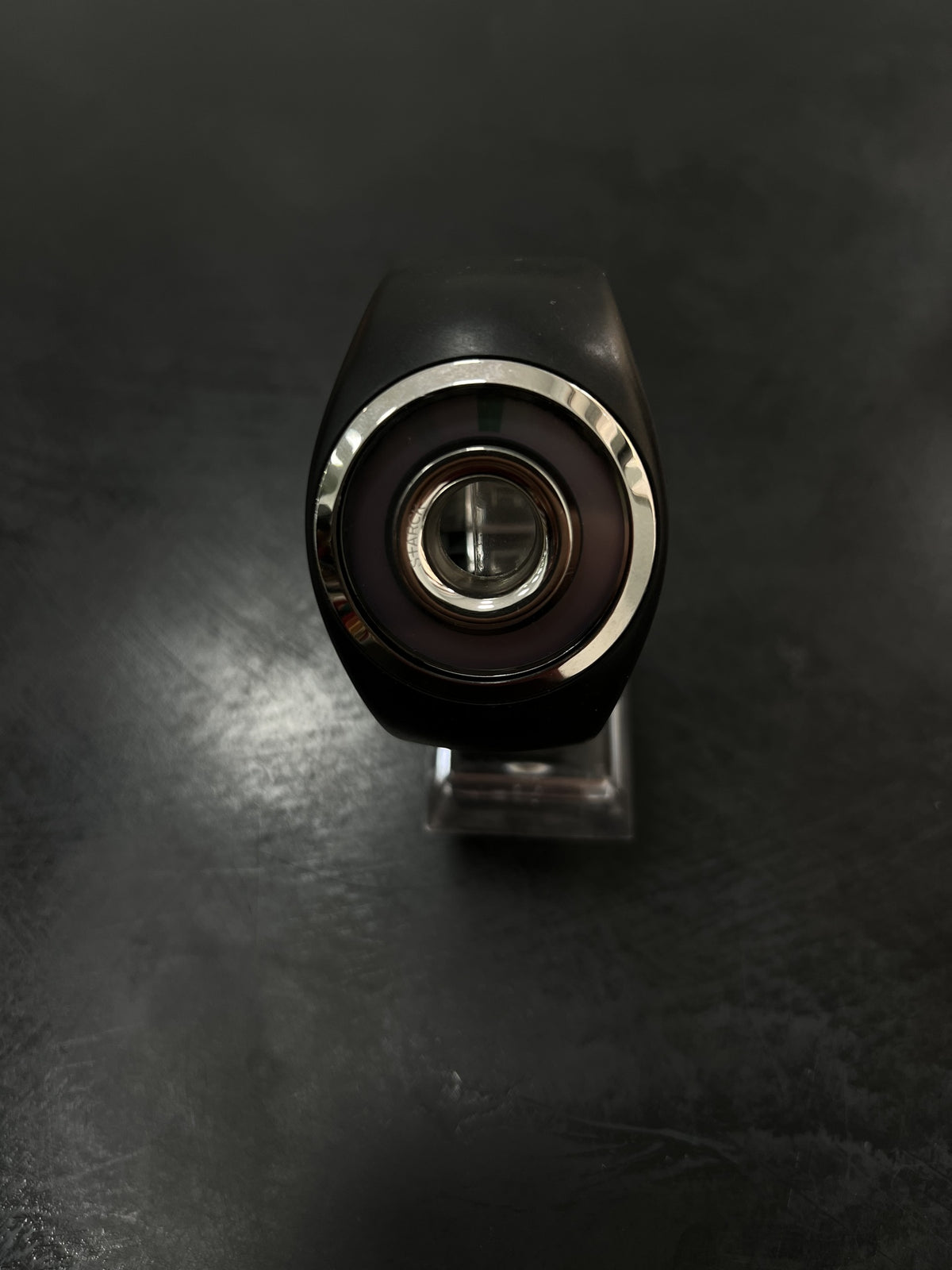 Reloj negro con pantalla digital central y aro en tono plateado.
