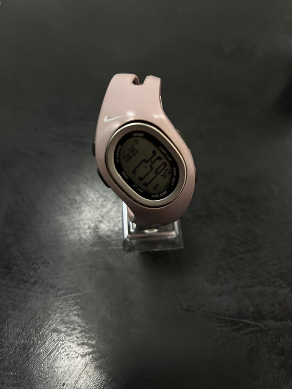 Reloj digital Nike con caja ovalada, correa rosa y logotipo blanco.